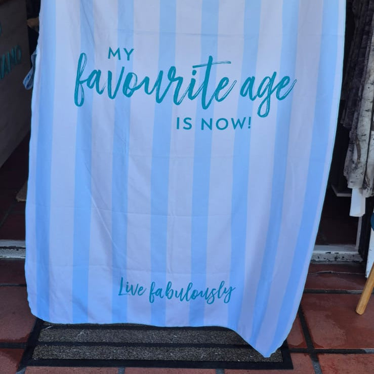 Light blue towel with text and Politano logo on a store entrance.